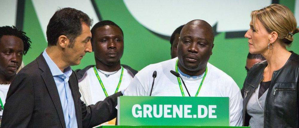 Cem Özdemir (li.) und die neue Bundesvorsitzende Simone Peter (re.) hören der Rede des Nigerischen Flüchtlings Bashir Zakari zu.