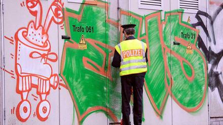 Den Schmierern auf der Spur. Ein Polizist untersucht ein Graffiti. 