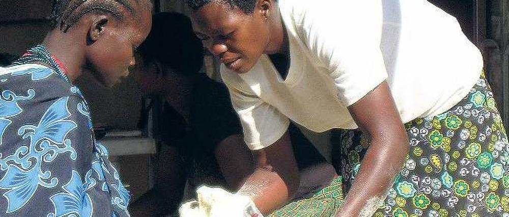 Ein Kind mit Kind. Dieses Mädchen im Osten Ugandas hat früh selbst ein Baby bekommen. Das Welternährungsprogramm (WFP) versorgt diese Kinder mit Nahrungsmitteln.