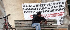Afrikaner betrachtet ein Plakat gegen Abschiebung auf dem Oranienplatz in Berlin