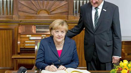So oder ähnlich könnte es aussehen, wenn Schwarz und Grün einmal einen Koalitionsvertrag unterzeichneten. Wahrscheinlich wird es dazu dieses Mal nicht kommen - vielleicht sogar nie. Angela Merkel und Winfried Kretschmann müssen sich wohl mit dieser Momentaufnahme schwarz-grüner Harmonie bei den Feierlichkeiten zum Tag der Deutschen Einheit in Stuttgart begnügen.