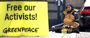 Eine Greenpeace-Aktivistin demonstriert vor einer Tankstelle in Berlin.