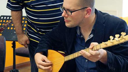 Johannes Schneider versucht sich am Saz-Spiel.
