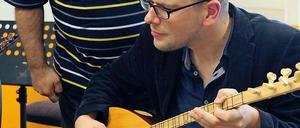 Johannes Schneider versucht sich am Saz-Spiel.