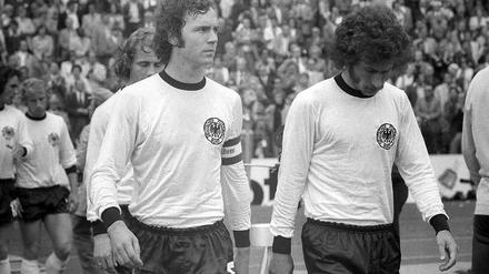 Kaiser Franz Beckenbauer (im Bild mit Paul Breitner). 1974 waren die Haare lang, heute gibt es Geld von Gazprom. 
