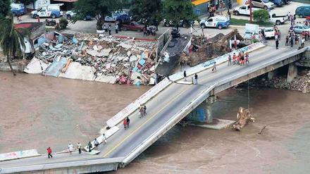 Brücke kollabiert. Bevölkerung und Urlauber müssen sich andere Wege aus der zerstörten Stadt Acapulco suchen.