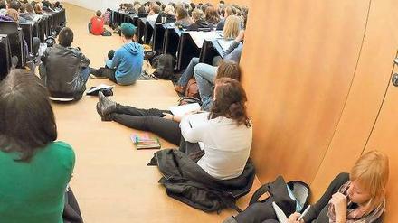 Studierende sitzen im Hörsaal und schreiben mit.