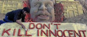 Sandskulptur mit einem Toten und dem Text "Don't kill innocent people"