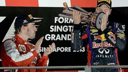 Der obligatorische Kuss: Vettel und die Siegertrophäe nach dem Nachtrennen von Singapur. Alonso applaudiert.