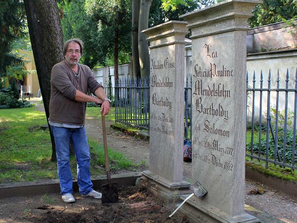 Landschaftsarchitekt Martin Ernehrt steht  mit einer Schaufel an der Grabstätte der Mendelssohn-Familie, um den Boden aufzulockern.