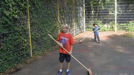 Der 10-jährige Germain macht mit seinen Freunden aus dem Jugendclub outreach den Fußballkäfig sauber.