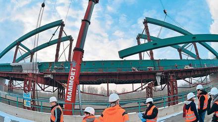 Eine Bahn-Brücke wird bei Halle (Saale) von einem Kran in ihre endgültige Position gehoben.