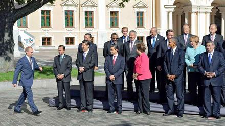 Achtung! Haltung! Der Chef kommt. G-20-Gastgeber Wladimir Putin eilt dem "Familienfoto" des Gipfels entgegen. Alle anderen stehen schon, reichlich gelangweilt, wie es scheint, stramm. Der zweite von rechts in der ersten Reihe, US-Präsident Barack Obama wirkt eher angespannt als heiter, während neben ihm Brasiliens Präsidentin Dilma Roussef das Gespräch mit der zweiten Reihe sucht. In der zweiten Reihe macht Bundeskanzlerin Angela Merkel ihre berühmte Raute und neben ihr sucht der britische Premierminister David Cameron nach Haltung.