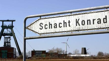 Wegweiser mit Schacht Konrad, im Hintergrund Förderturm und Windräder