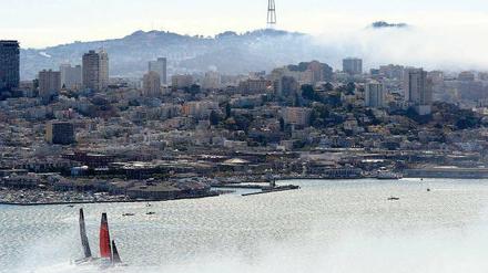 Stadtarena. Vor der Kulisse von San Francisco und 80 000 Zuschauern am Hafen sind die Teams aus Neuseeland (rotes Boot) und den USA (schwarzes Boot) meist gleichauf. Foto: dpa