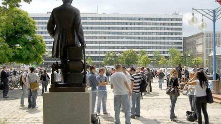 Studenten stehen vor dem Hauptgebäude der Technischen Universität.