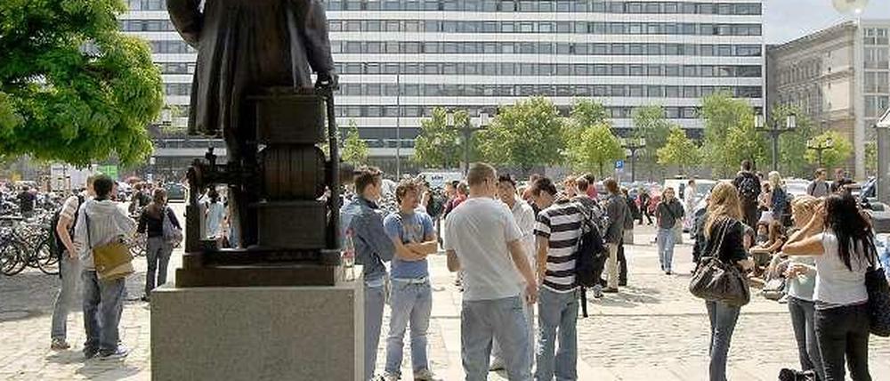 Studenten stehen vor dem Hauptgebäude der Technischen Universität.