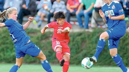 Gelungenes Freundschaftsspiel. Turbine und Nordkorea (im Bild Ra Un Sim) und die Potsdamerinnen Tabea Kemme (l.) und Stefanie Draws (r.) trennten sich 2:2. Foto: dpa