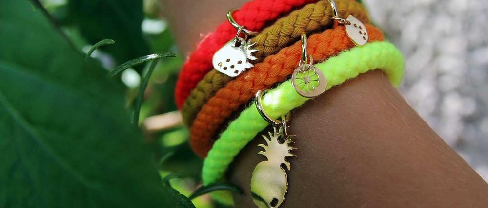 Vier Kordelarmbänder mit goldenem Anhänger von Sabrina Dehoff.