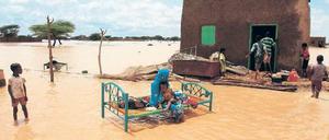 Eine Frau sitzt mit ihrem Kind in der Nähe der sudanesischen Hauptstadt Khartoum auf ihrem Bett. Ihr Haus wurde nach heftigen Regenfällen von den Fluten des Nils stark beschädigt. 