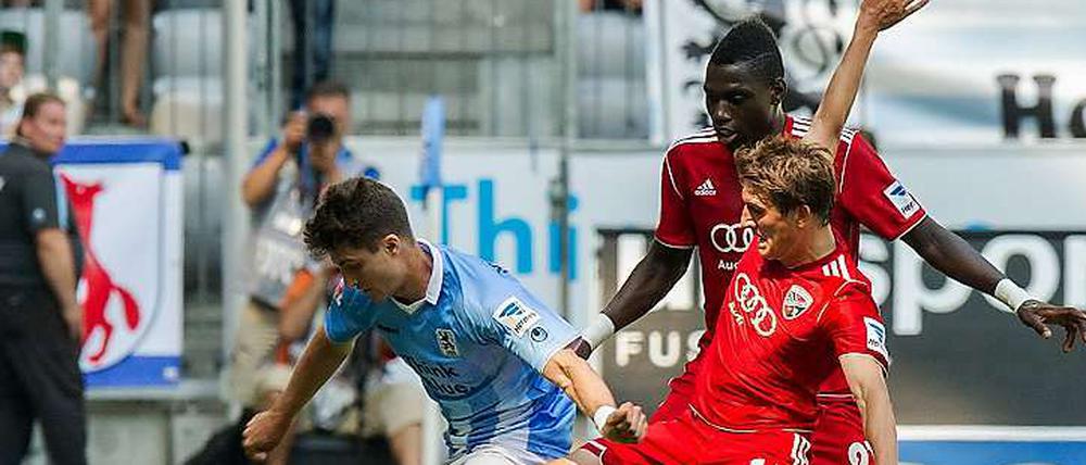 Eine Szene aus dem Spiel. Münchens Moritz Stoppelkamp (l) im Kampf um den Ball mit Andreas Buchner (M) und Danny da Costa aus Ingolstadt.