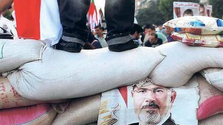 Aufrüstung. Die Mursi-Anhänger in den Protestcamps wollen auf keinen Fall weichen. Sie lassen es auf eine Konfrontation ankommen und schichten Sandsäcke zum Schutz der Camps auf.Foto: Asmaa Waguih/Reuters