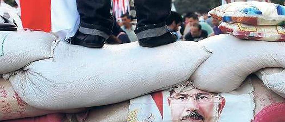 Aufrüstung. Die Mursi-Anhänger in den Protestcamps wollen auf keinen Fall weichen. Sie lassen es auf eine Konfrontation ankommen und schichten Sandsäcke zum Schutz der Camps auf.Foto: Asmaa Waguih/Reuters