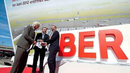 Schön wär’s gewesen. Architekt Meinhard von Gerkan (l-r), Berlins Regierender Bürgermeister Klaus Wowereit und (noch) Ministerpräsident des Landes Brandenburg, Matthias Platzeck (beide SPD) enthüllten am 09.06.2011 in Berlin am Flughafen Tegel ein Plakat des neuen Hauptstadt-Airports BER in Schönefeld. Die Sache mit dem Juni 2012 hat bekanntlich nicht geklappt.