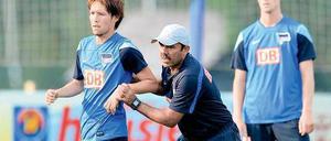 Hertha-Trainer Jos Luhukay schiebt Spieler Hajime Hosogai über den Trainingsplatz.