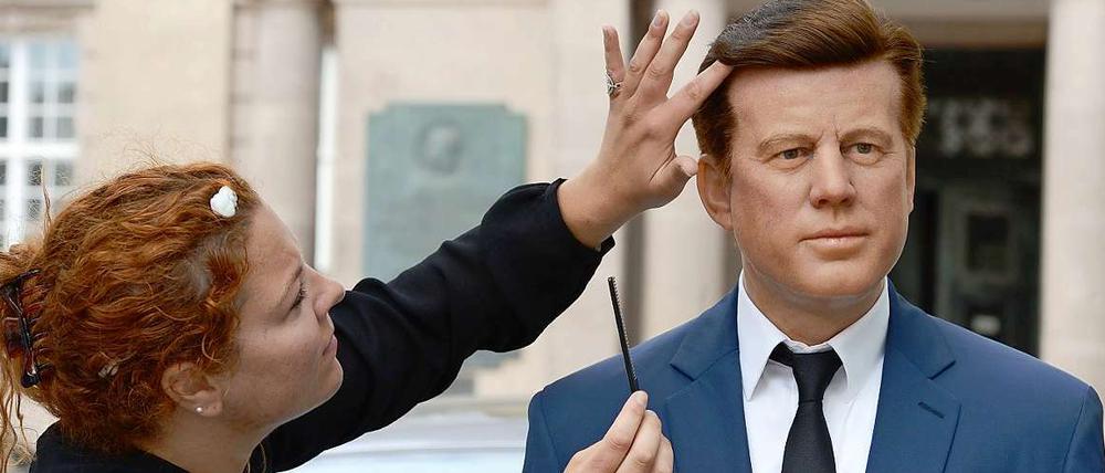 Eine Mitarbeiterin des Wachsfigurenkabinetts Tussauds legt letzte Hand an eine Kennedy-Figur, die zum Jahrestag seiner Rede zum Fototermin vor das Schöneberger Rathaus gebracht wurde.