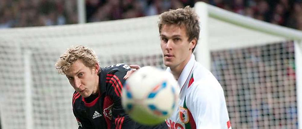 Hart am Mann. Sebastian Langkamp (rechts, noch im Trikot der Augsburger) im Duelle mit Stefan Kießling.