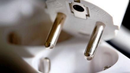 Stecker über einer Steckdose