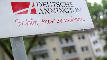 Ein Firmenschild der Deutschen Annington vor einem Mietshaus.