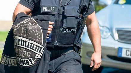 Kutte über dem Arm. Ein Beamter trägt eine Rockerkluft des Clubs Gremium MC. Die berüchtigten Gruppen Hells Angels, Gremium MC und weitere liefern sich blutige Revierkämpfe. Es geht dabei um Drogen, Waffen und Prostitution. Deswegen wurden die Clubs jetzt verboten.