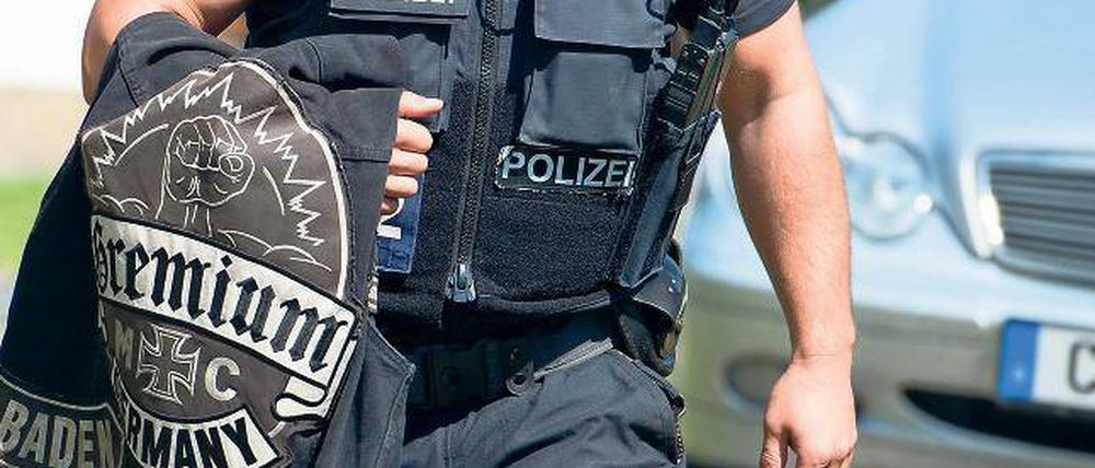 Kutte über dem Arm. Ein Beamter trägt eine Rockerkluft des Clubs Gremium MC. Die berüchtigten Gruppen Hells Angels, Gremium MC und weitere liefern sich blutige Revierkämpfe. Es geht dabei um Drogen, Waffen und Prostitution. Deswegen wurden die Clubs jetzt verboten.