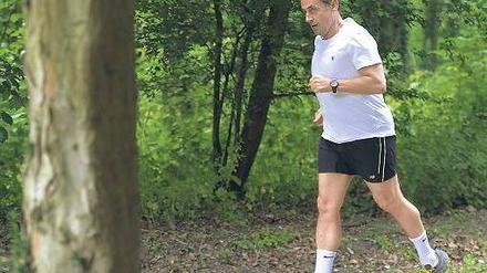 Weglaufen hilft nicht. Eher unfreiwillig kehrt der leidenschaftliche Jogger Nicolas Sarkozy nach dem Skandal um seine UMP wieder ins politische Geschehen zurück. Foto: AFP