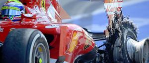 Ein Ferrari fährt mit einem geplatzten Hinterreifen.