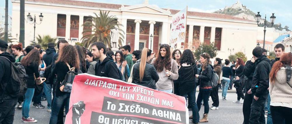 „Löscht unsere Schulden, nicht unsere Hochschulen.“ Studierende demonstrieren vor der Universität Athen gegen die Kürzungspläne der Regierung. Allein in diesem Jahr werden die Zuschüsse für die Hochschulen um ein Viertel gesenkt. Viele Unis können Strom und Telefon nicht mehr bezahlen, Büromaterial wird knapp.