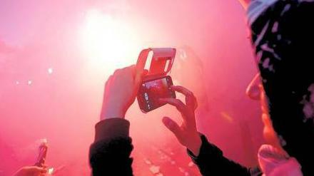 Filmen und fotografieren, was passiert, das tun viele Demonstranten, wie hier eine Frau, auf dem Taksim-Platz in Istanbul. Sie posten die Bilder und Videos in sozialen Netzwerken wie Twitter und Facebook - zum Missfallen der türkischen Regierung. Foto: Reuters