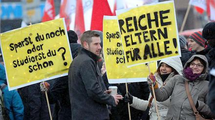 Junge Studenten, die auf Plakaten fordern: "Suche reiche Eltern."