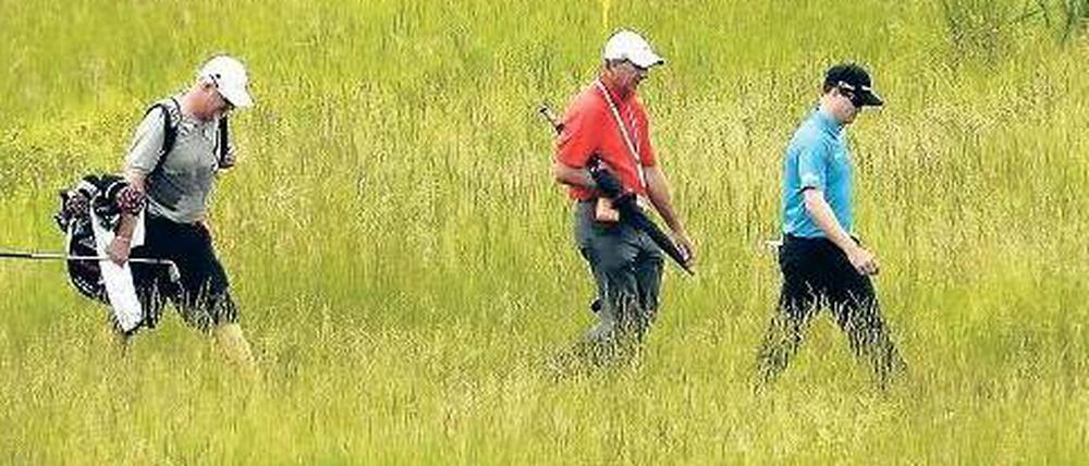 Schlagen und stapfen. Zach Johnson (rechts) und Gefolge.