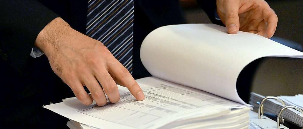 Ein Mitglied des NSU-Untersuchungsausschusses blättert in Erfurt (Thüringen) im Landtagsgebäude in einem Aktenordner. Am Dienstag war bekannt geworden, dass die sogenannte 129er-Liste sogar 500 Personen umfasst. 