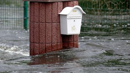 Briefkasten an Mauer vom Wasser umgeben