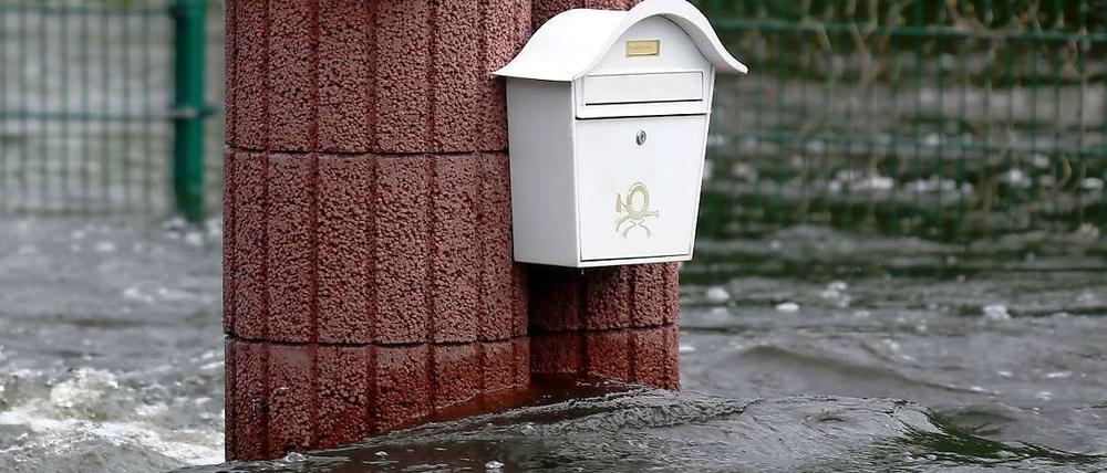 Briefkasten an Mauer vom Wasser umgeben