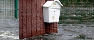 Briefkasten an Mauer vom Wasser umgeben