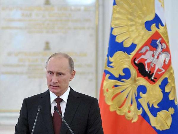 Putin vor Fahne am Mikrofon