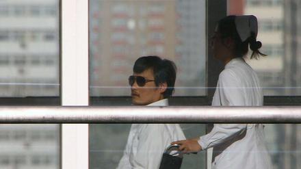 Der blinde Dissident Chen wird im Rollstuhl durch ein Krankenhaus in Peking geschoben.