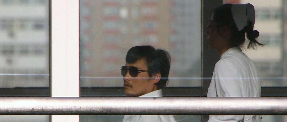  Der blinde Dissident Chen wird im Rollstuhl durch ein Krankenhaus in Peking geschoben.
