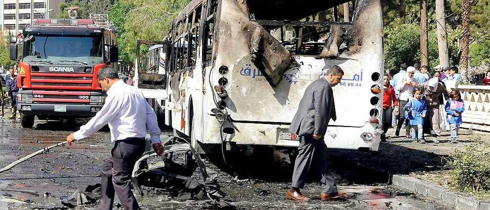 Zeichen der Zerstörung. Ein ausgebrannter Bus steht am Straßenrand in Damaskus. 