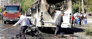 Zeichen der Zerstörung. Ein ausgebrannter Bus steht am Straßenrand in Damaskus. 